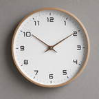 Round wooden wall clock with a white face and brown hands on a gray wall.