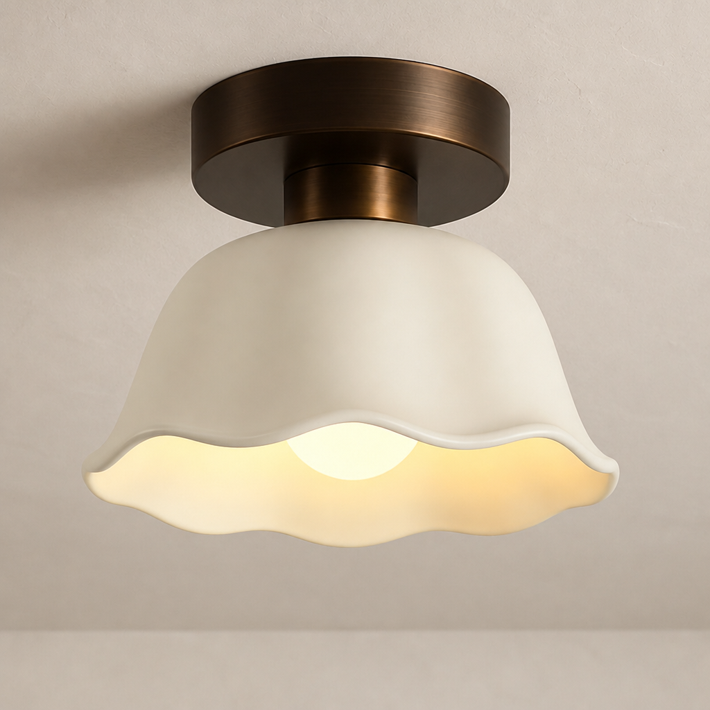 Bronze flush-mount ceiling light with cream scalloped glass shade glowing warmly.