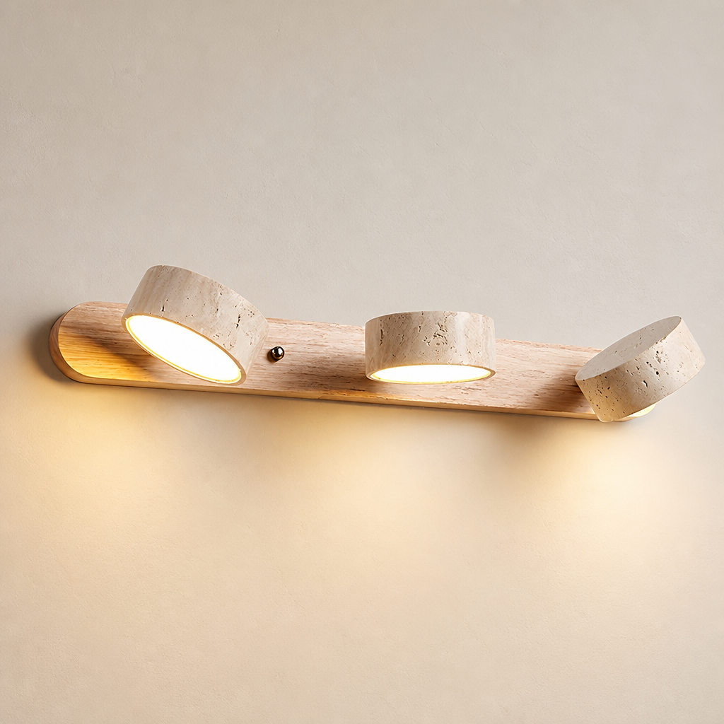 Wooden three-light wall fixture with warm glowing cylindrical spotlights.