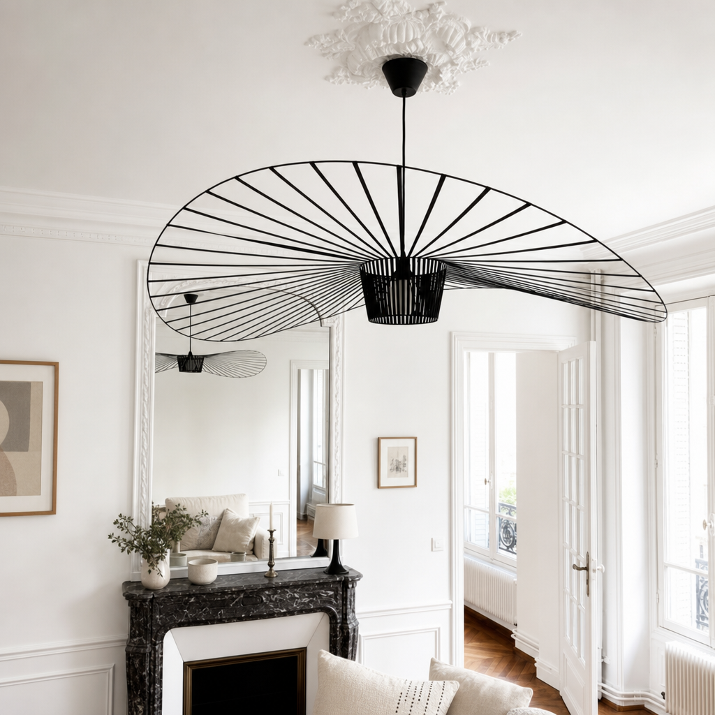 Black wire fan-shaped pendant light hanging in a bright white living room.