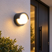 Dark Round Hood Outdoor LED Wall Light, 12W, mounted beside an entrance.