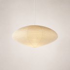 Warm ribbed paper pendant lamp with a wide oval shade hanging from a white cord.
