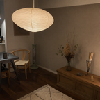 Large ribbed oval paper pendant lamp glows warmly above a cozy dining corner.