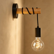 Wooden wall-mounted lamp with black cord and glowing Edison bulb.