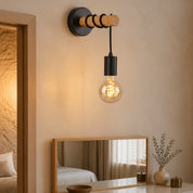 Wall-mounted wood and black metal sconce with a hanging amber Edison bulb.