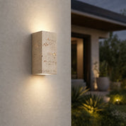 Rectangular beige stone wall light casting warm up and down illumination on an exterior wall.