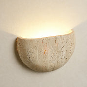 Beige textured half-bowl wall sconce casting a warm upward glow.
